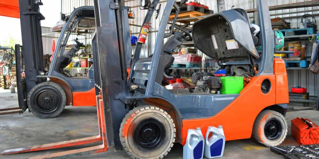 Two forklifts parked in a garage for annual inspection and maintenance.